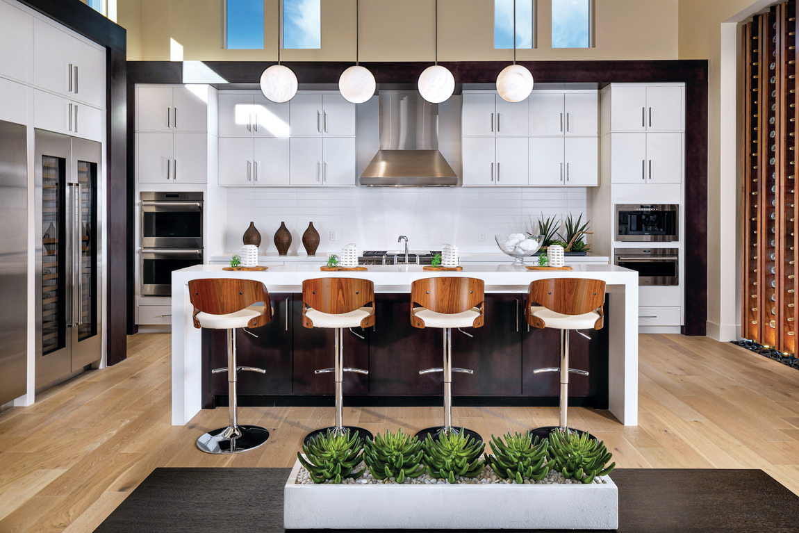 contemporary kitchen featuring waterfall island, pendant lighting, and innovative cabinetry