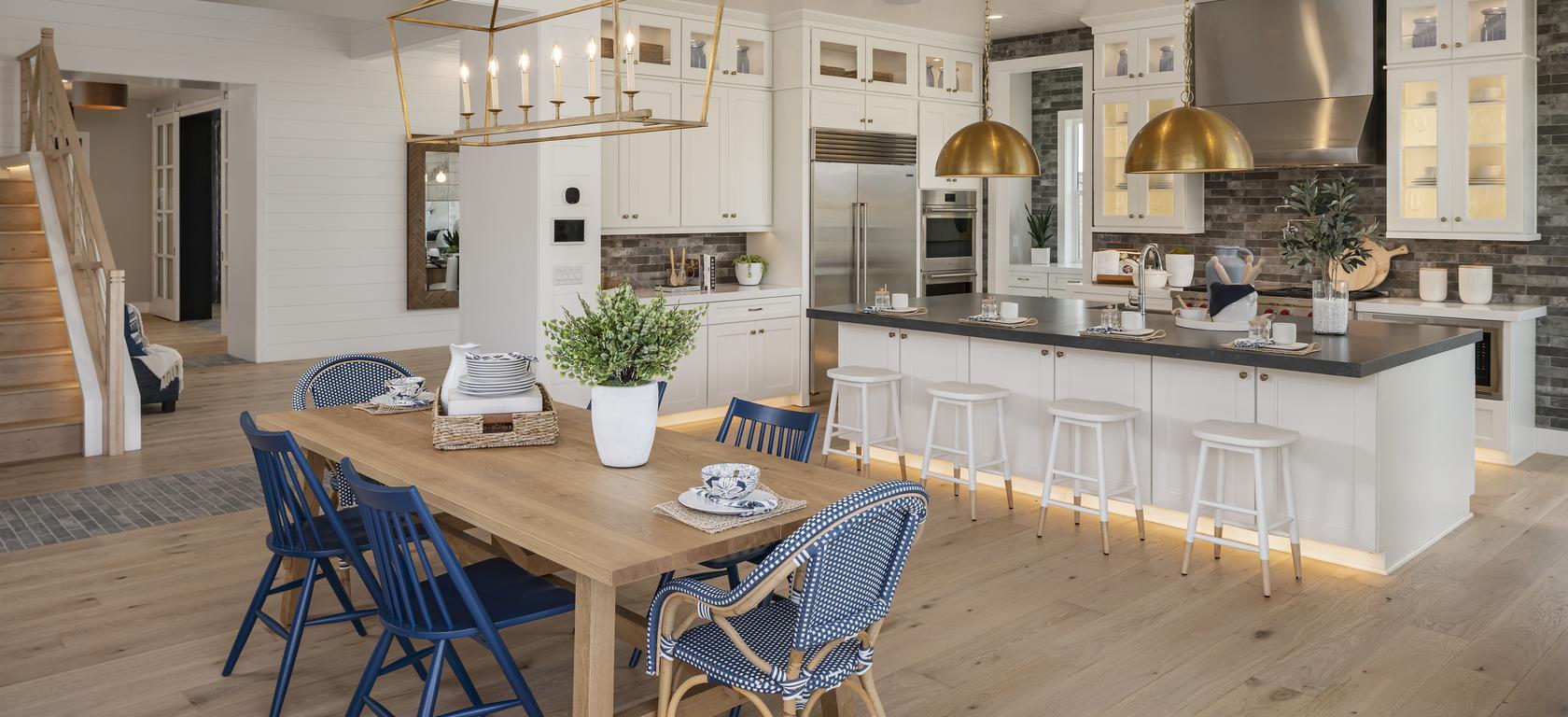 Kitchen with blue wicker chairs and center island with toe kick lighting