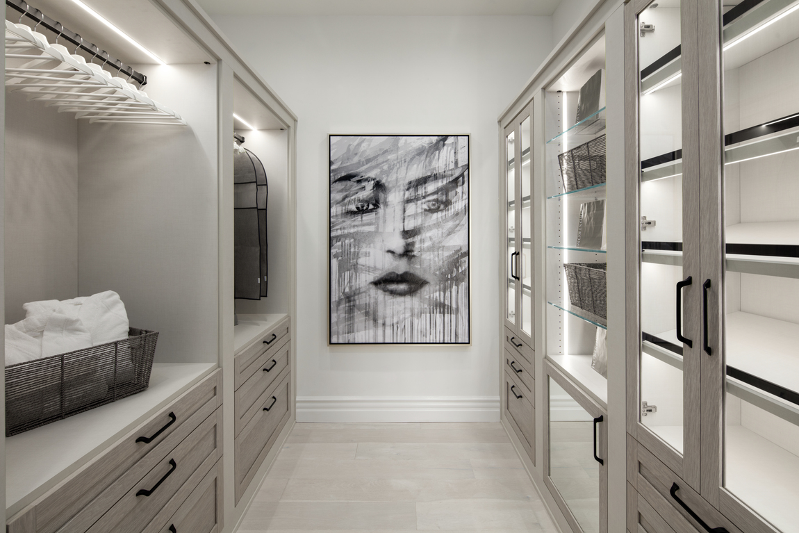 Grey neutral closet with white paint and artwork. 