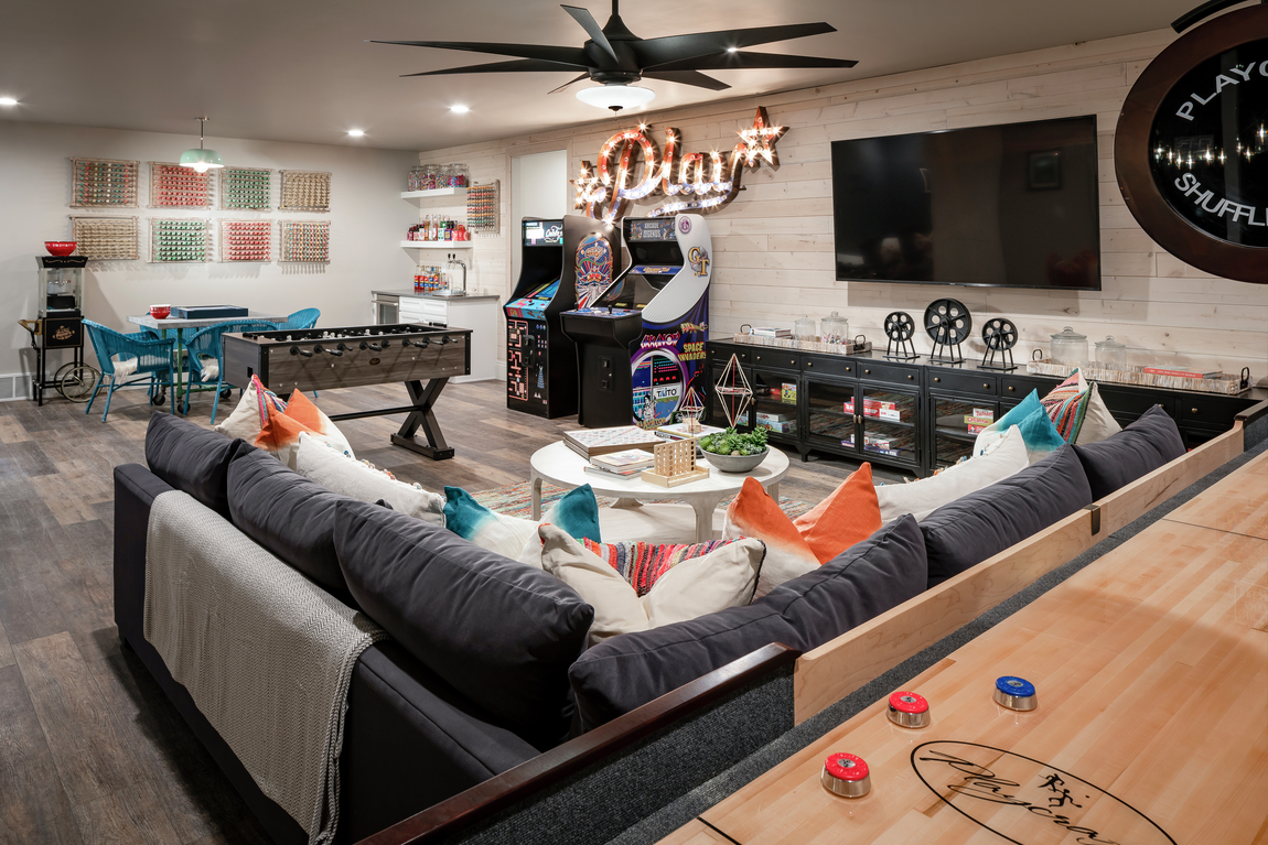 Basement with transitional ceiling fan and couch 