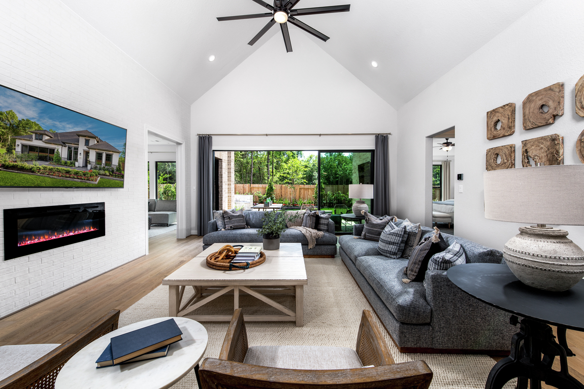 Great room with seven blade ceiling fan, fireplace and white walls