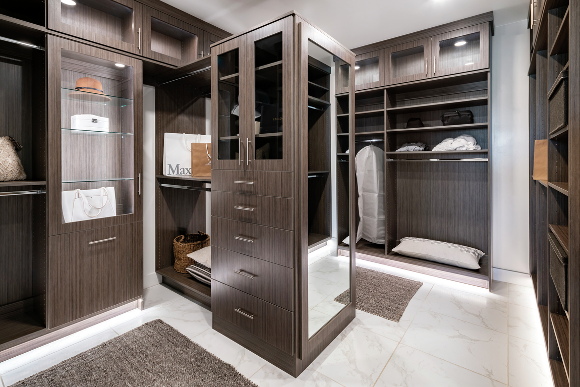 Closet with dark wood color and marbled tile floor.
