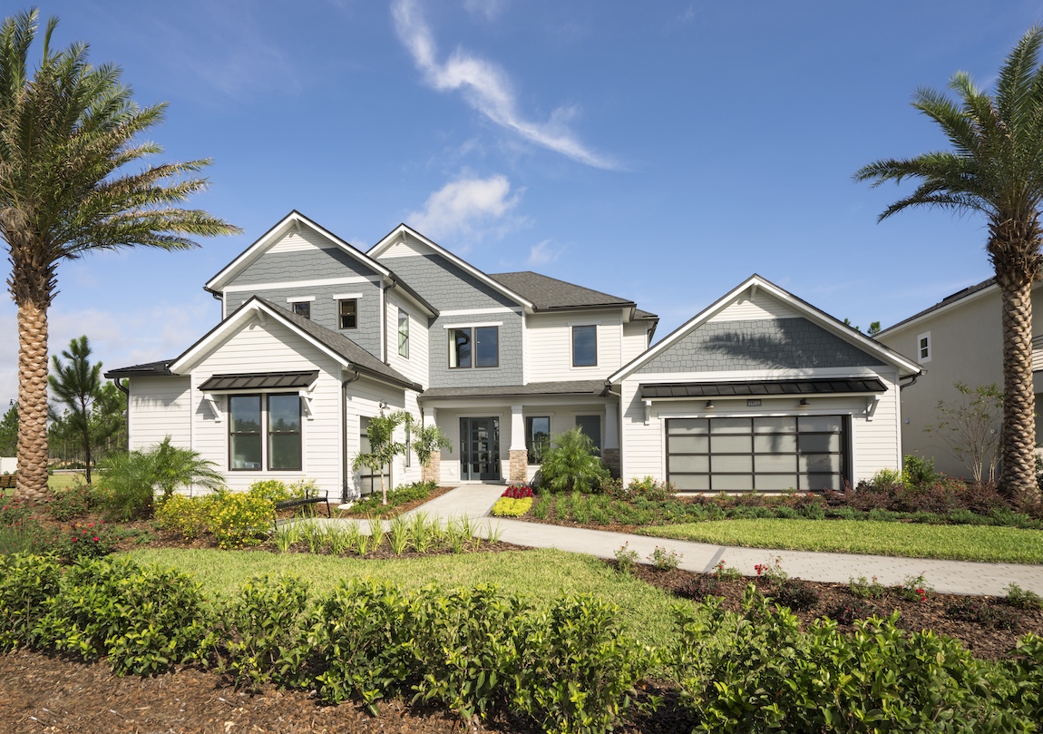 A luxury home with glass garage doors and metal shed roofs.