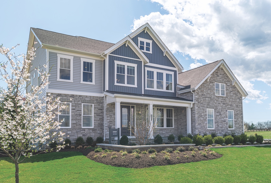 A luxurious suburban home featuring natural materials, such as wood and stone.