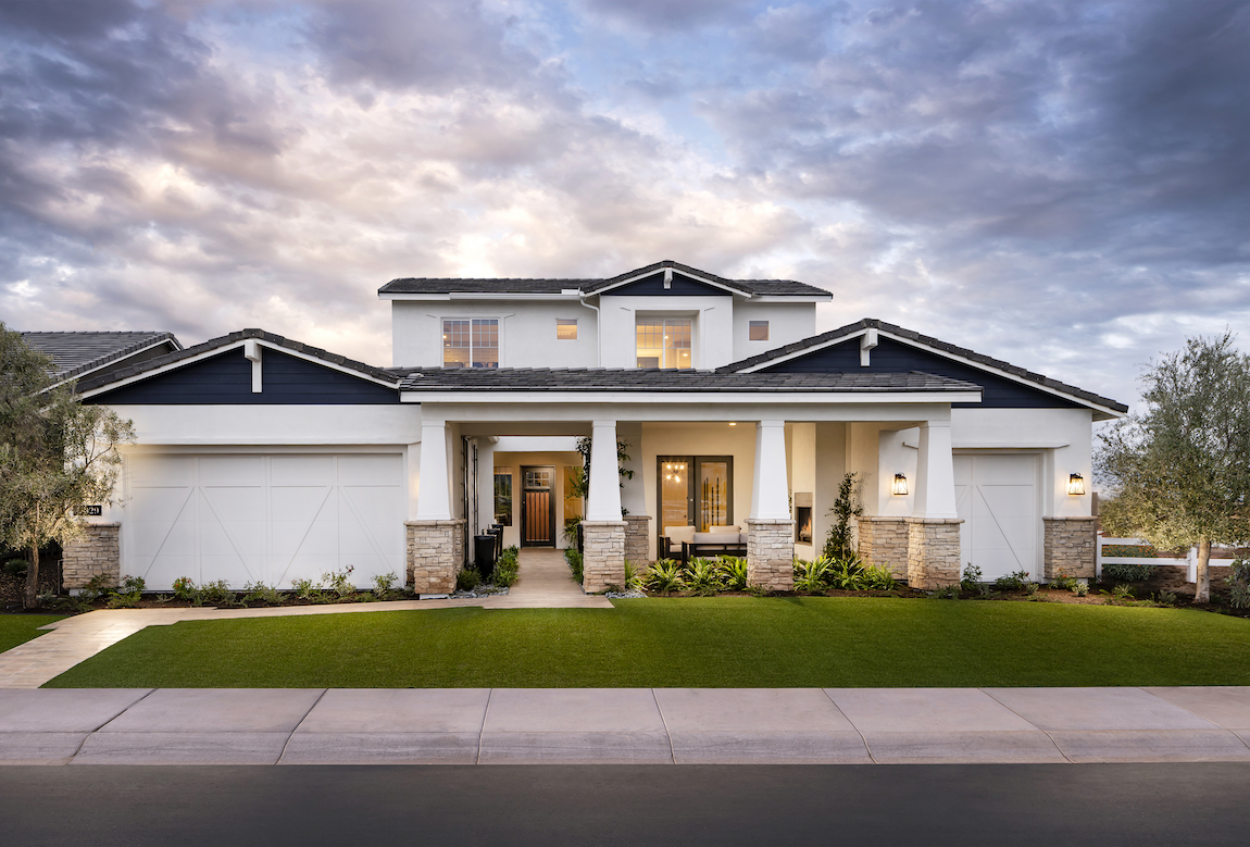 A large, luxurious home with multiple columns and gables.