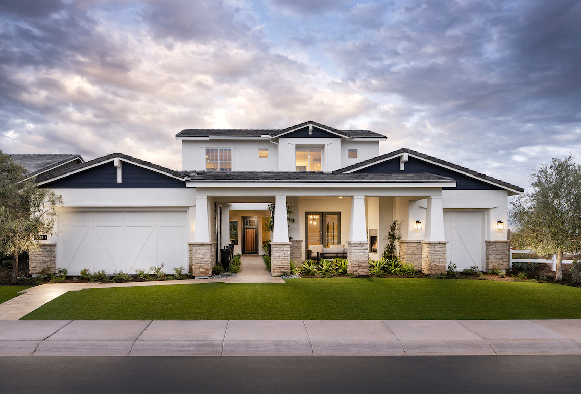 A large, luxurious home with multiple columns and gables. 