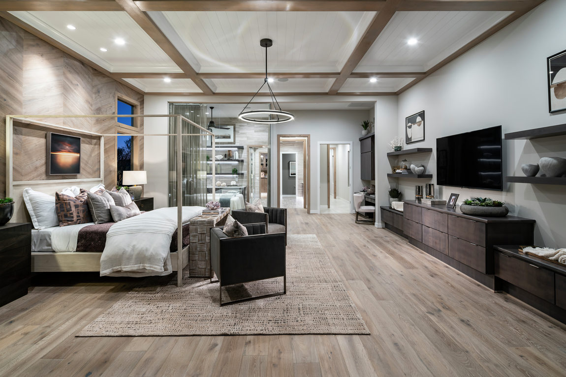 A large bedroom with grey accents and grey colored walls.