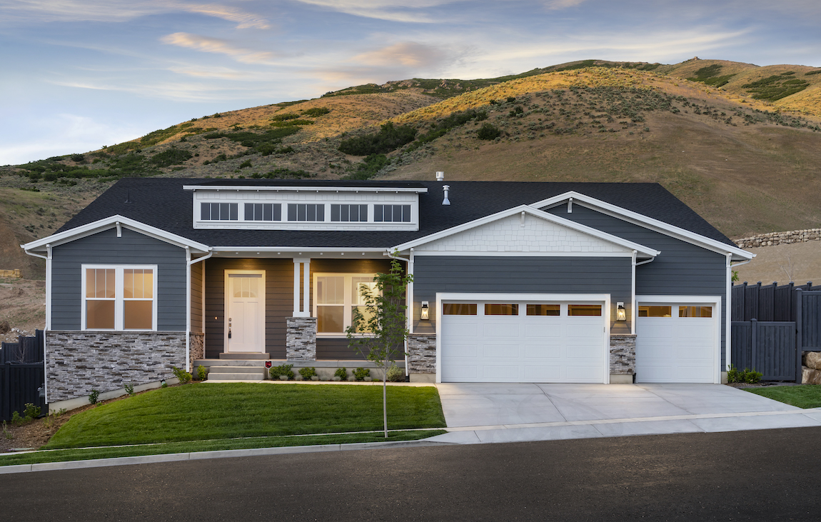 Exterior of a craftsman style house in Utah with mountains in the background. 