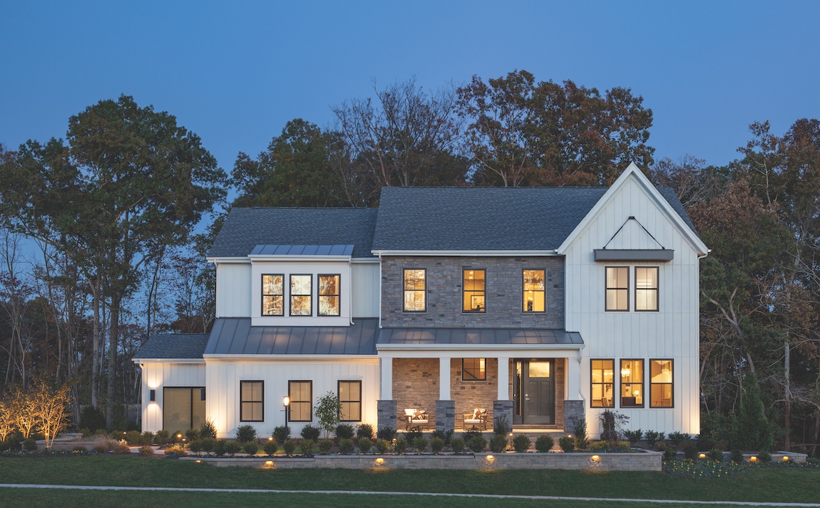 Exterior of a new construction home lit up with exterior lighting.