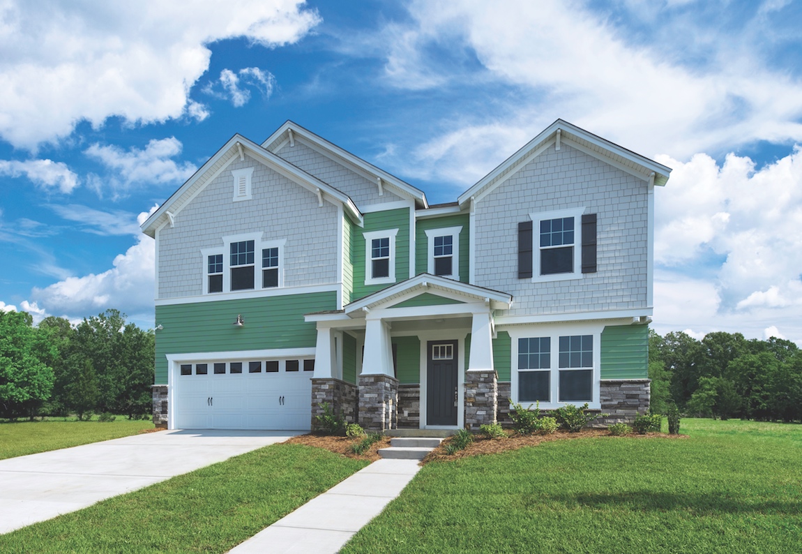 A craftsman style home with green and grey shutters.