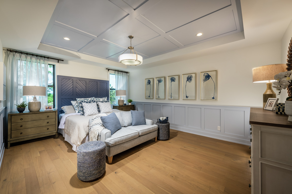 A primary bedroom with an accent ceiling design. 