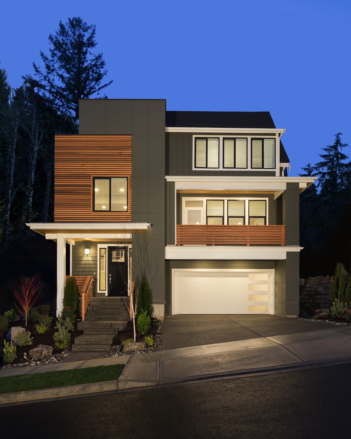 A modern design home with a dark green exterior and natural wood shiplap.