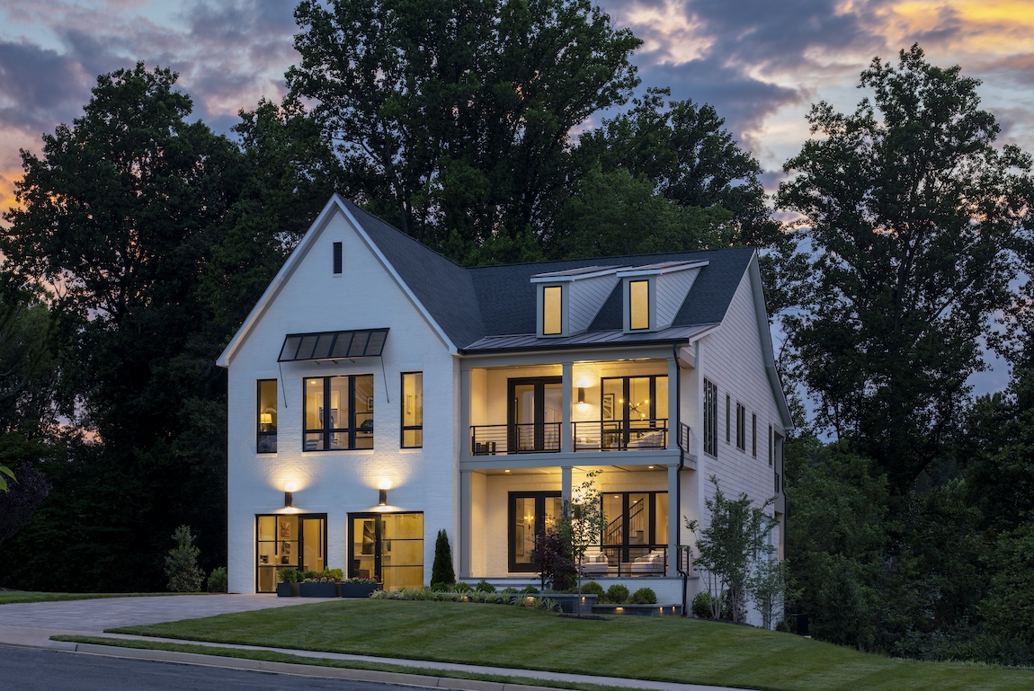 Toll Brothers model home in Virginia with lights on at dusk.