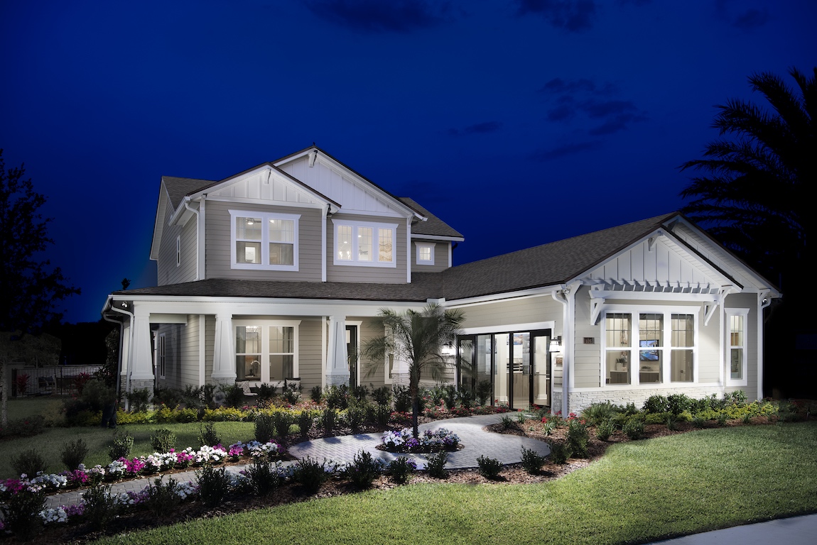 New construction home in Florida with lighting brightening the front yard.