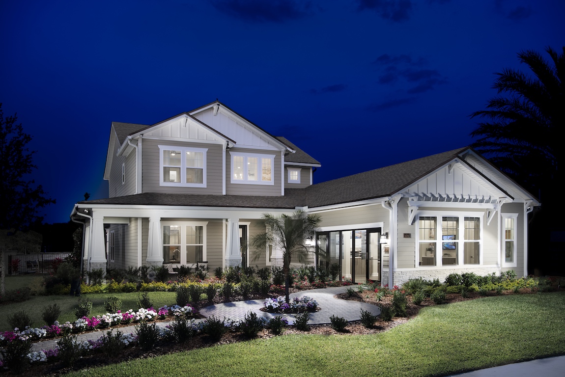 A luxury craftsman style home with a wrap around porch and single-hung windows.