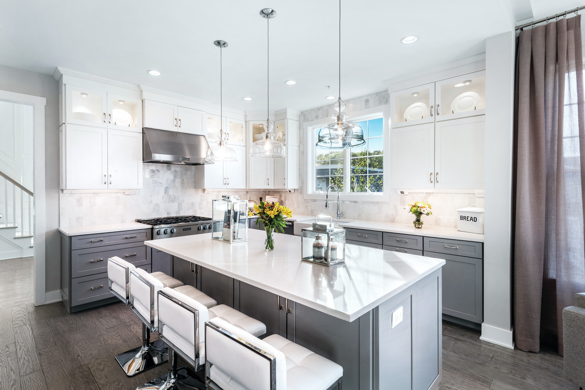 modern kitchen highlighted by pendant lighting and waterfall island