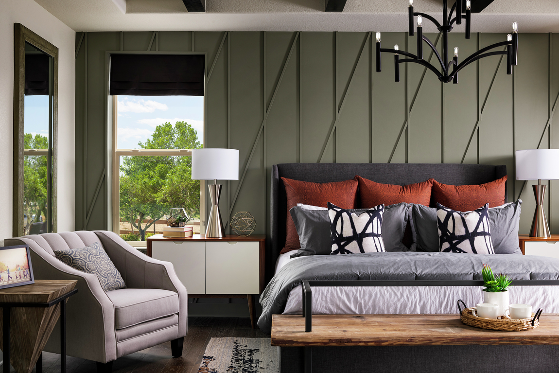 Primary bedroom in a luxury home with green textured walls.