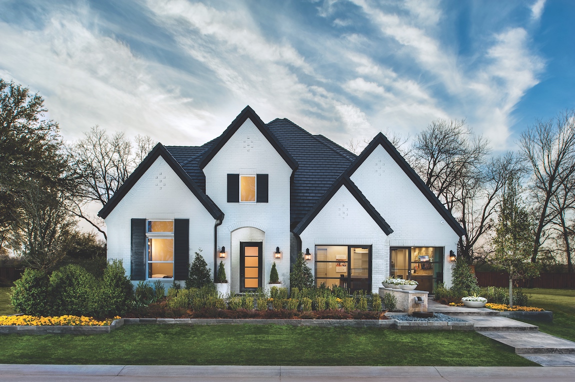 A Toll Brothers home in Texas with a white painted brick and dark trim exterior.