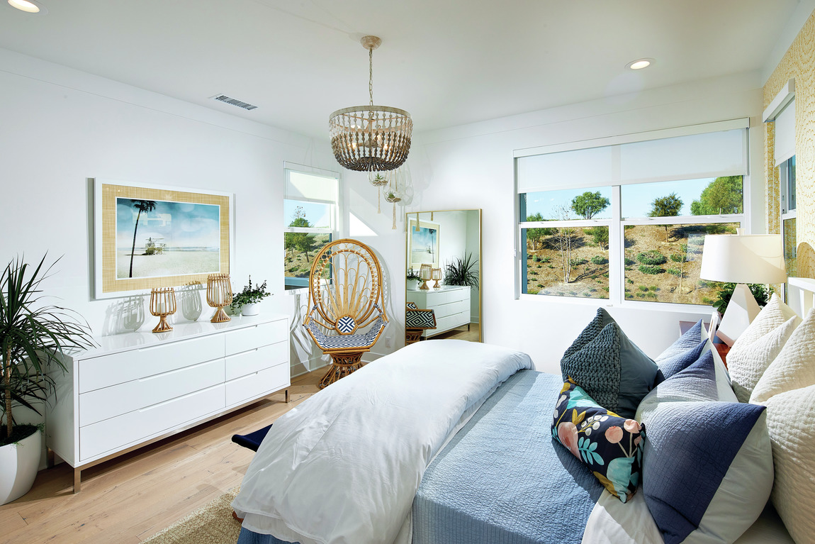 A bedroom with a boho design that features a mix of colors and textiles.