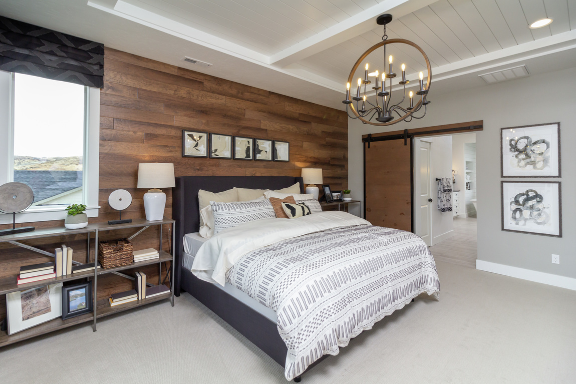 Bedroom with a wooden accent wall and a matching wooden barn door.