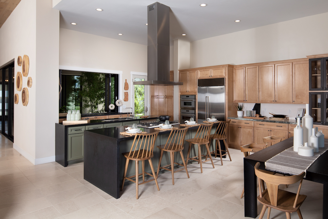 A large kitchen with a large center island that includes a black waterfall countertop.