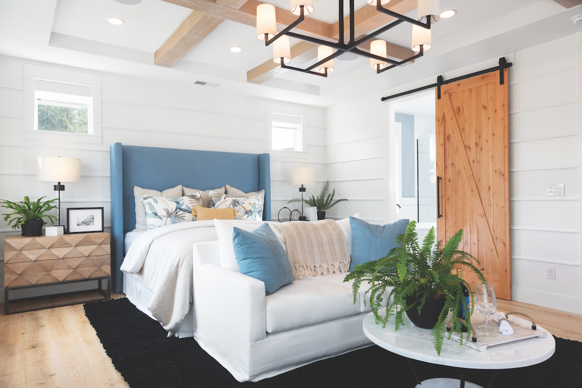 Wooden sliding barn door in a modern farmhouse bedroom.