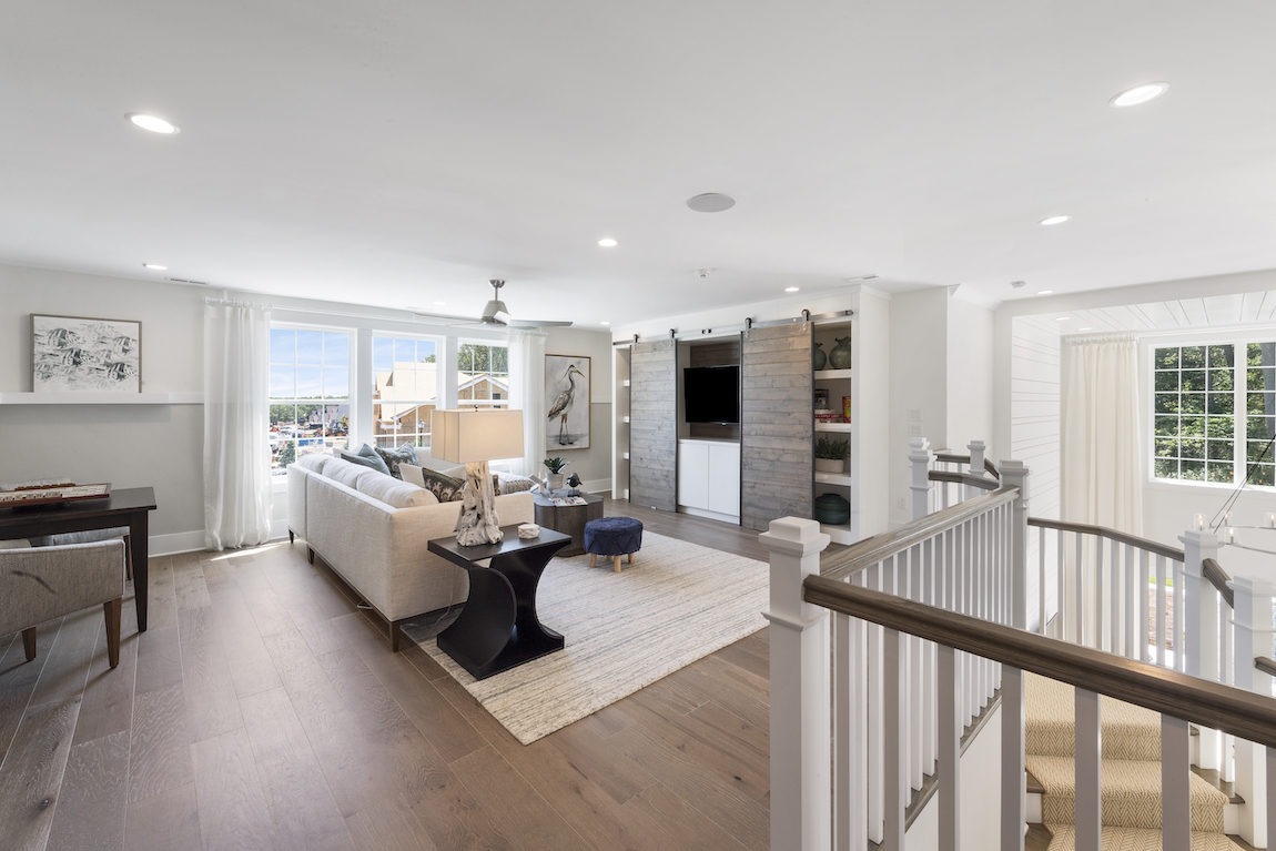 A living room with sliding doors that cover the entertainment system. 