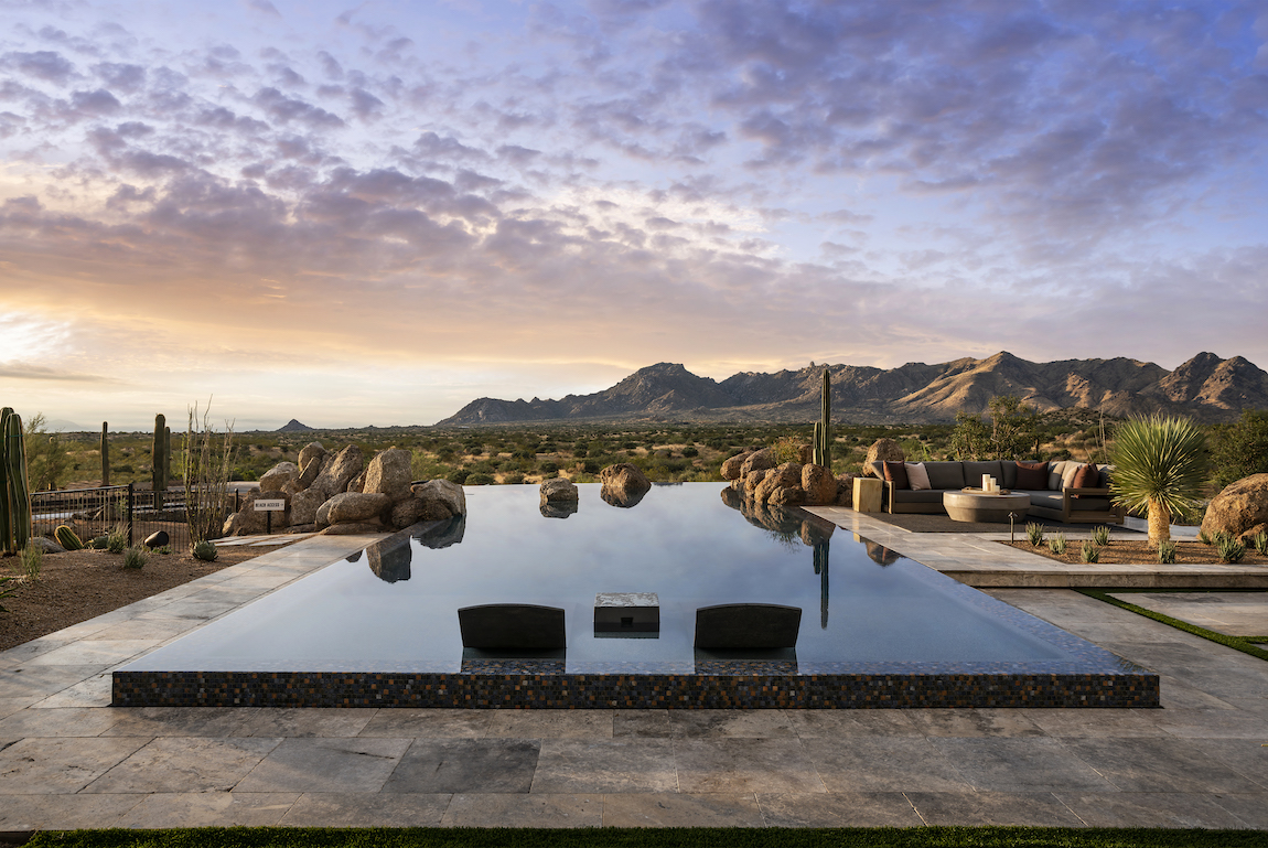 A luxury backyard pool in Arizona with a view of the desert and mountains.