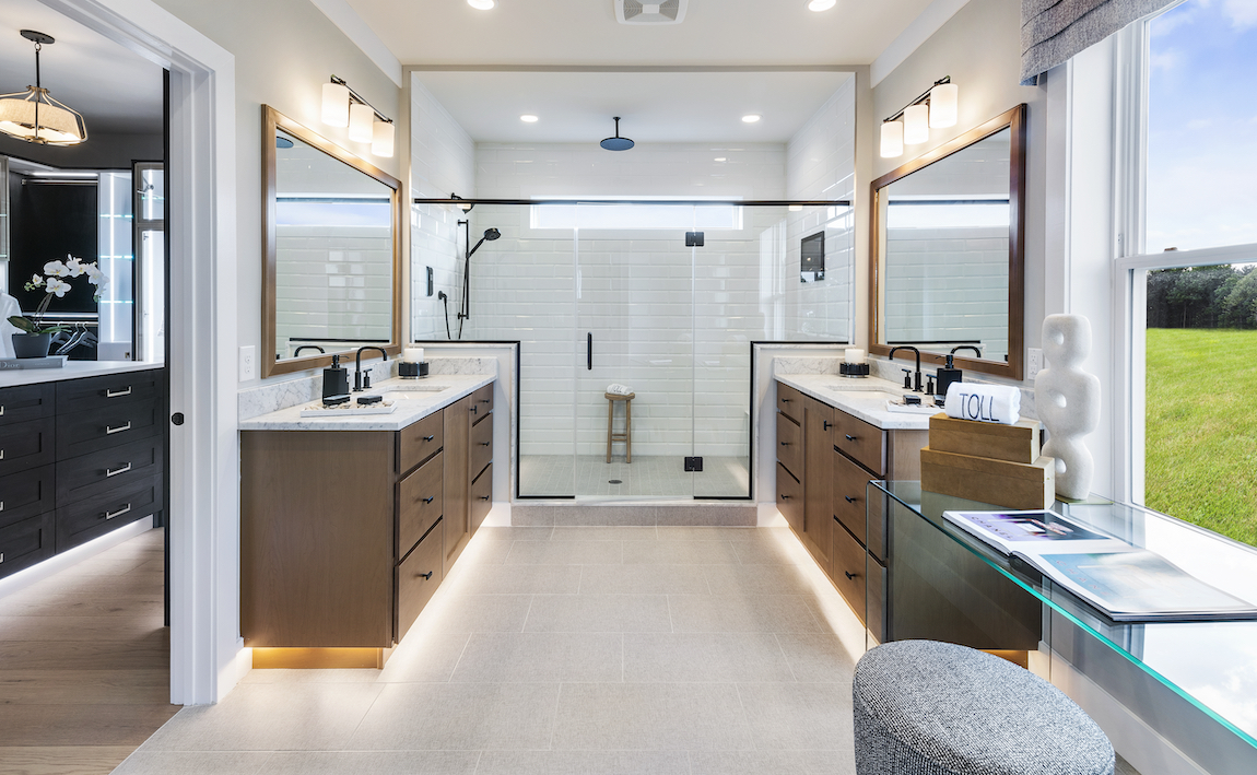A luxury bathroom with a modern farmhouse aesthetic and wooden cabinets.