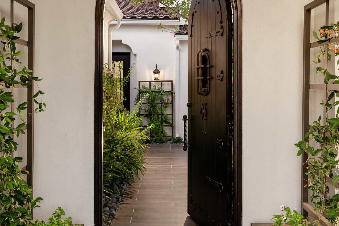 Black wooden door highlighted by subtle accents and arched framing