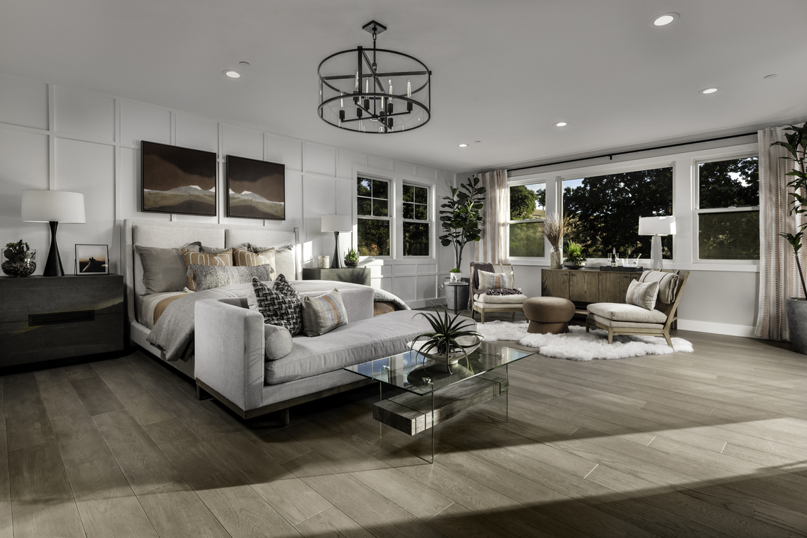 Luxury bedroom design with sitting area, and hardwood flooring. 