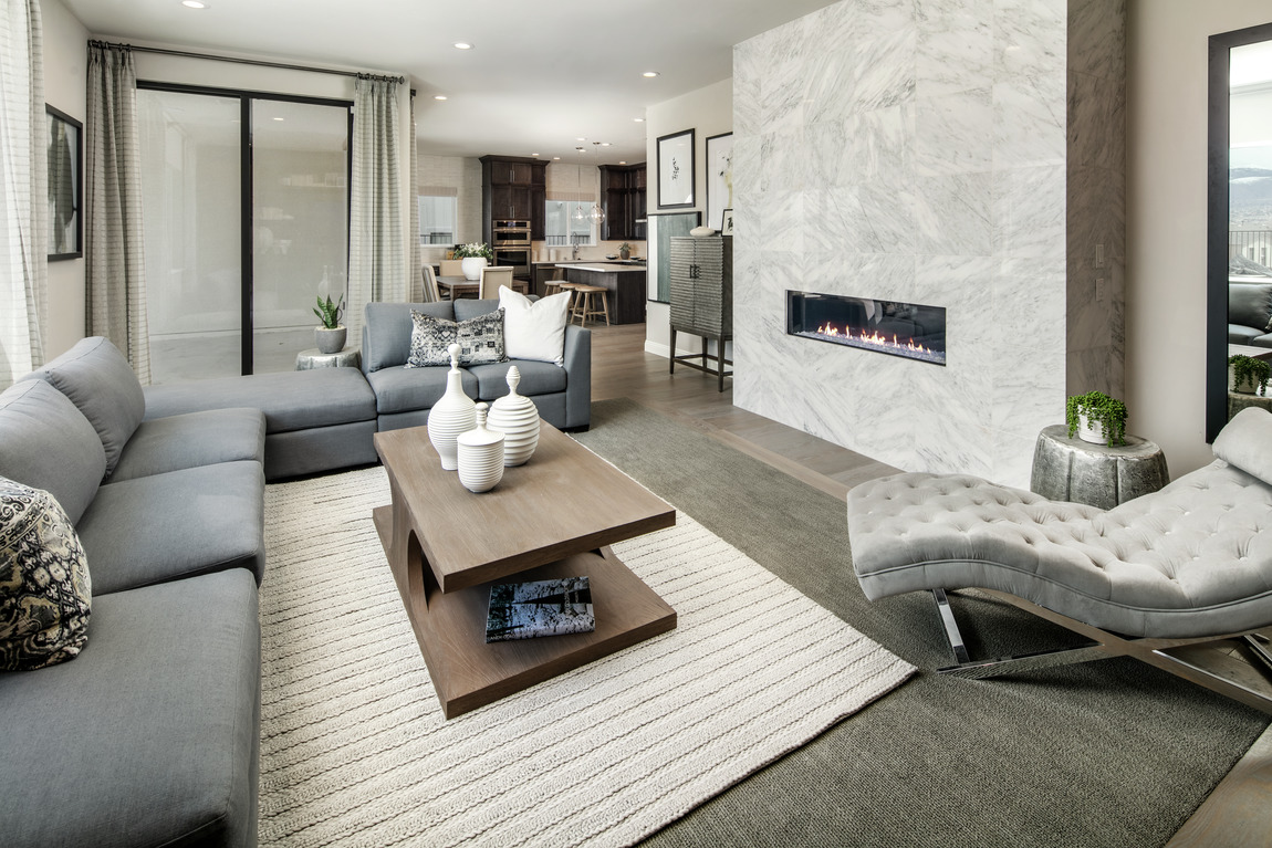 A living room with a linear fireplace built into tile wall.