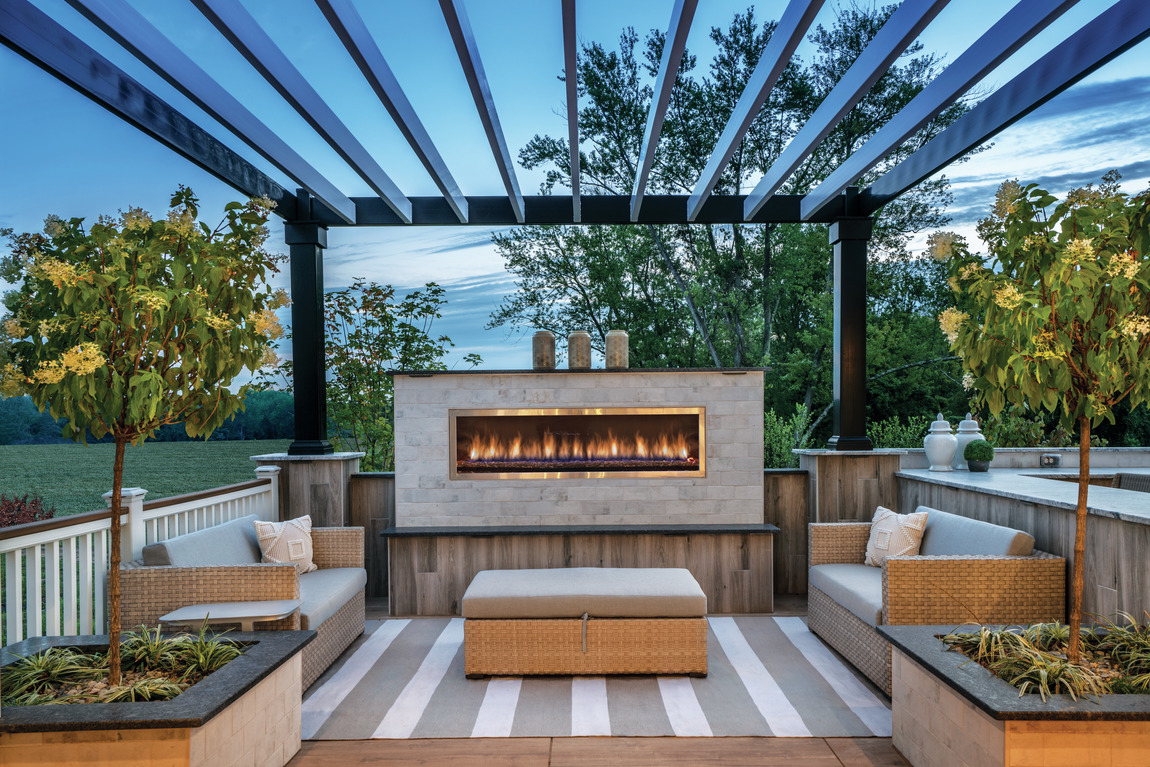 An outdoor patio with a large outdoor fireplace. 