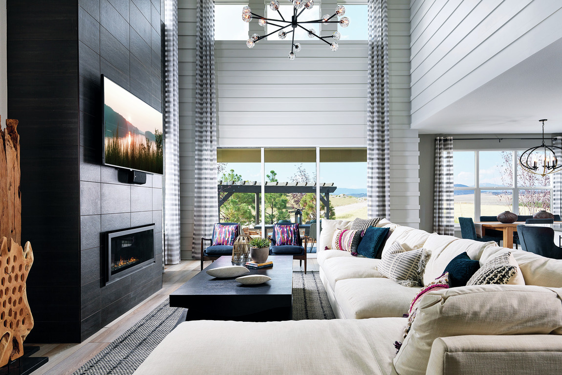 Matte black tile surrounding a fireplace in a luxury living room with tall ceilings.