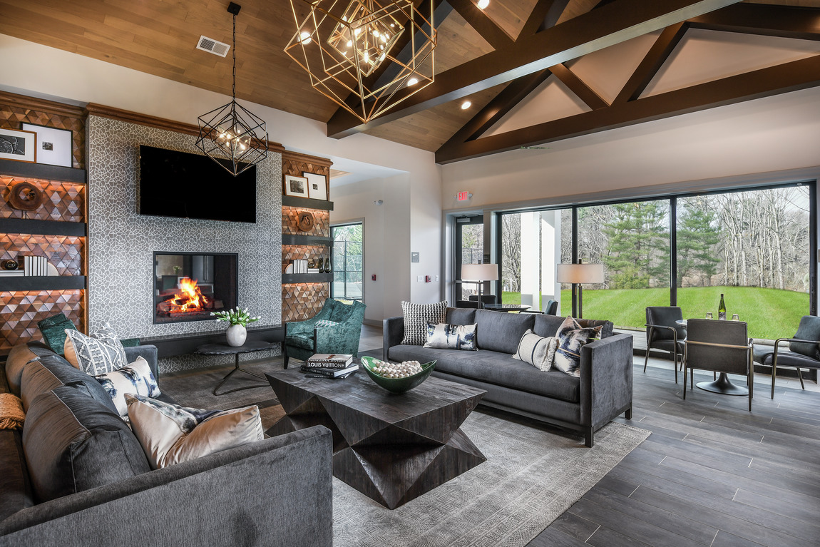 A great room with a large fireplace surrounded by textured tile.