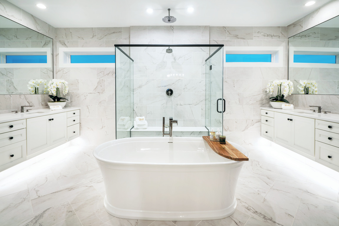 Luxury bathroom with a glass shower and toe kick lighting under cabinets.