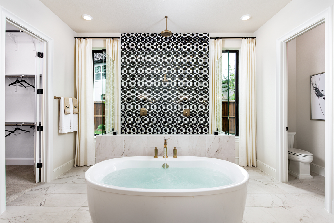 Luxury bathroom with gold hardware and an accent wall.