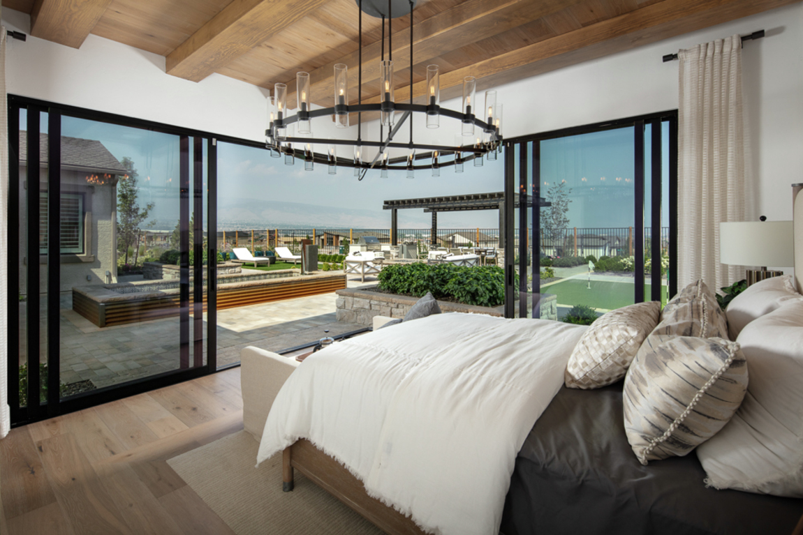 bedroom with outdoor transition and wood beam ceilings