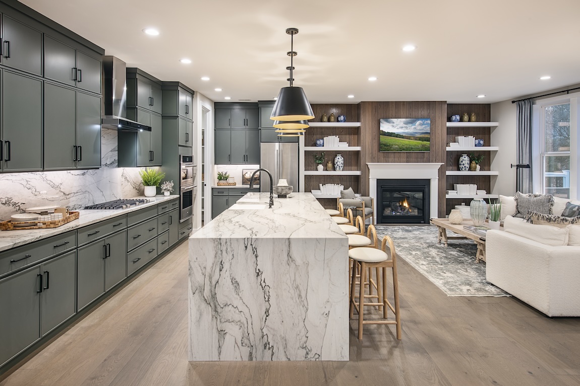 modern kitchen with marble waterfall island and green cabinetry