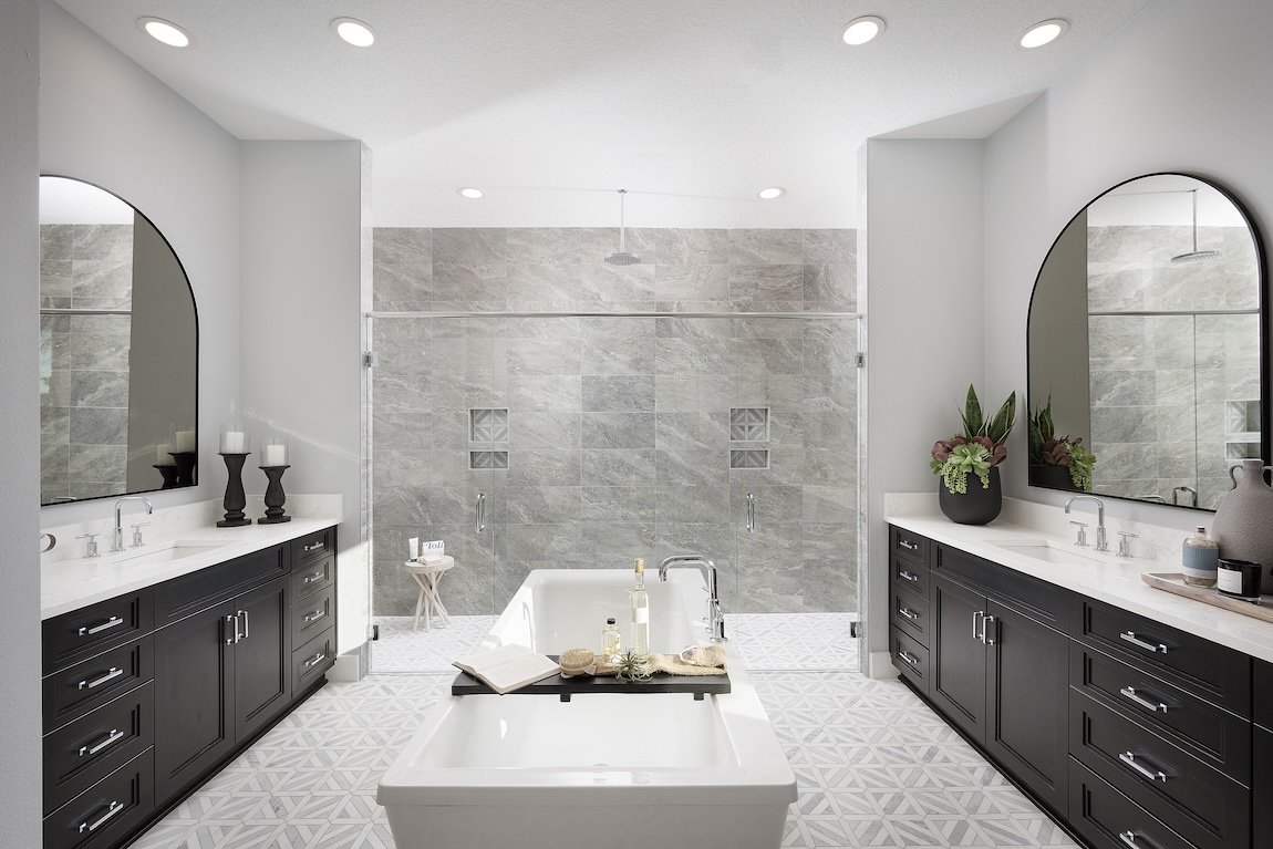 primary bathroom with dual vanities and black accents