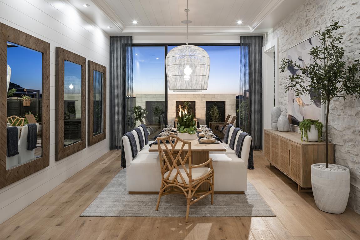 Formal dining table with shiplap and stone accent walls and sliding door entry to backyard