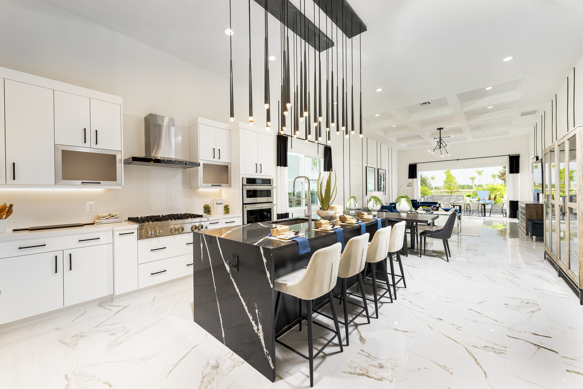 Kitchen with black quartz island and adjacent dining table with pendant light fixture