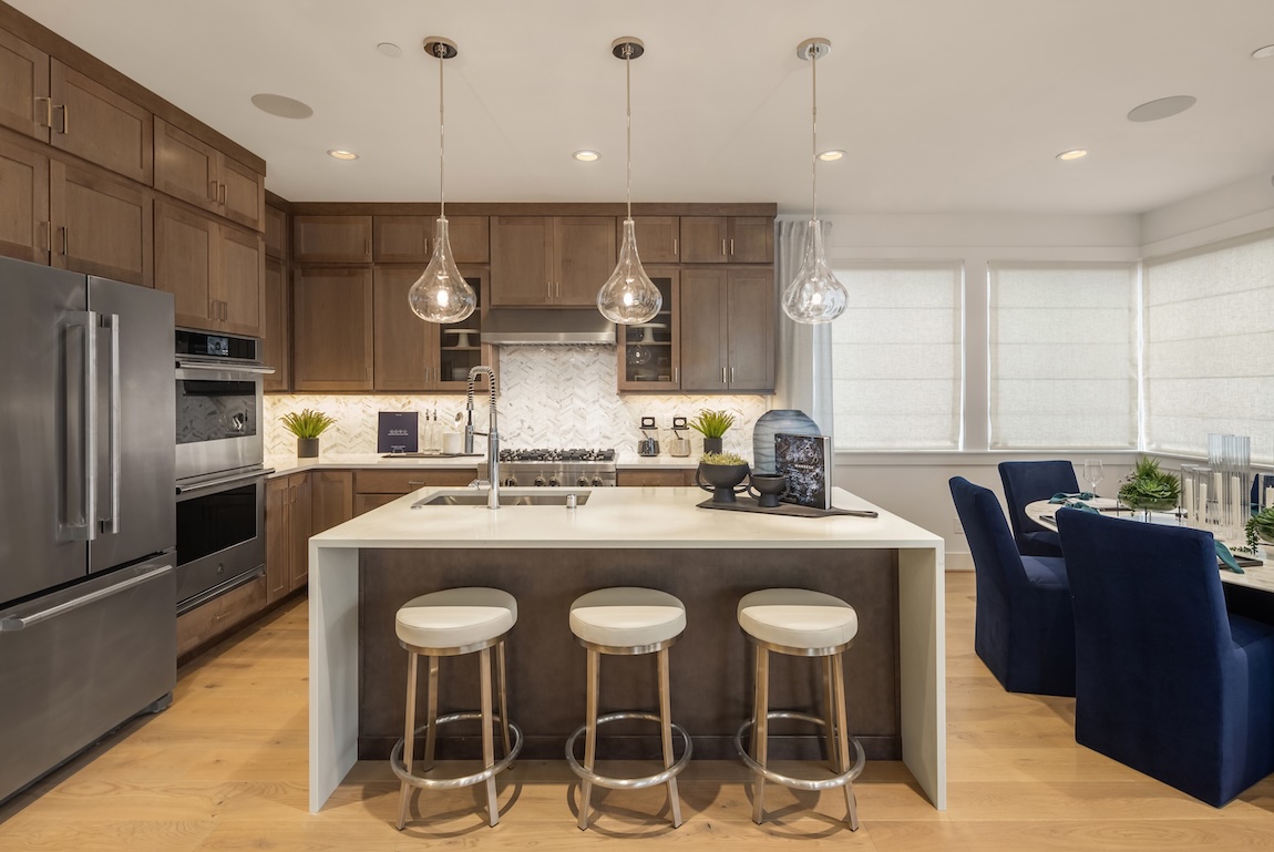 modern kitchen with glass pendant lights and a waterfall island