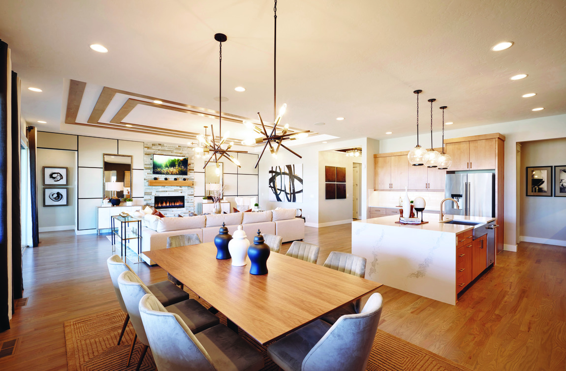 Great room including living room, kitchen, and breakfast area with contemporary interior design and light wooden flooring. 