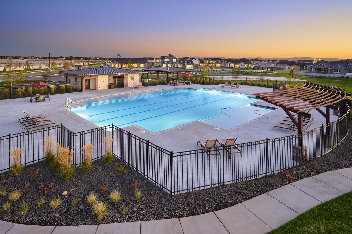 Pool and clubhouse with pagoda, lounge chairs and black gate.