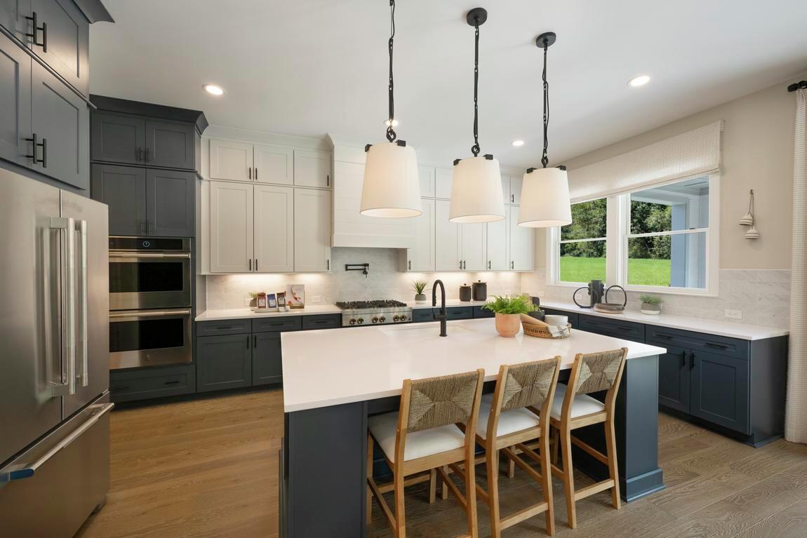 Light, airy kitchen with blue cabinetry and wood flooring