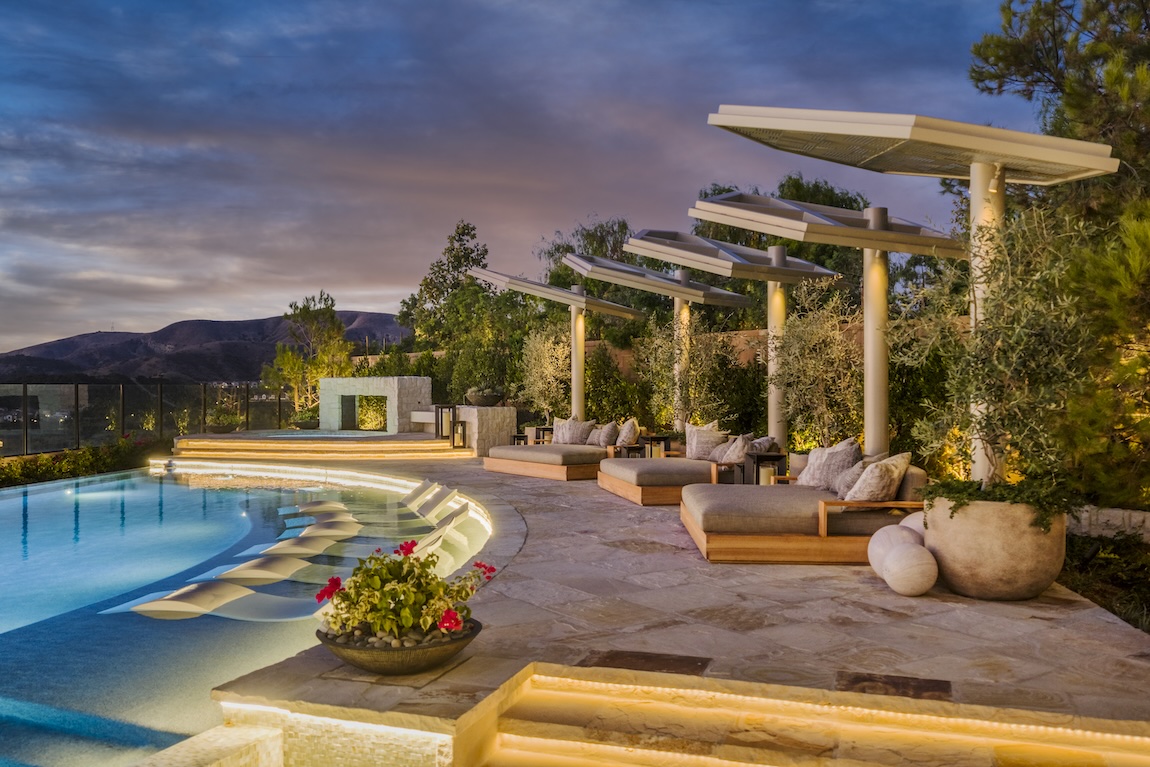 outdoor pool area with lounge chairs submerged in the water