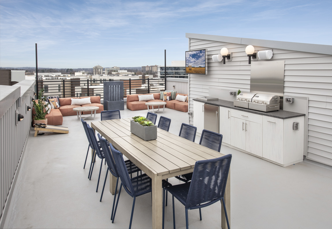 rooftop outdoor kitchen with table and seating area