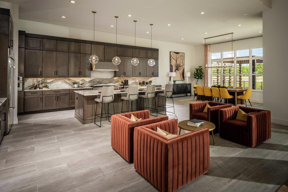 Spacious open-concept interior featuring contrasting furniture hues, neutral color schemes, and metallic fixtures.