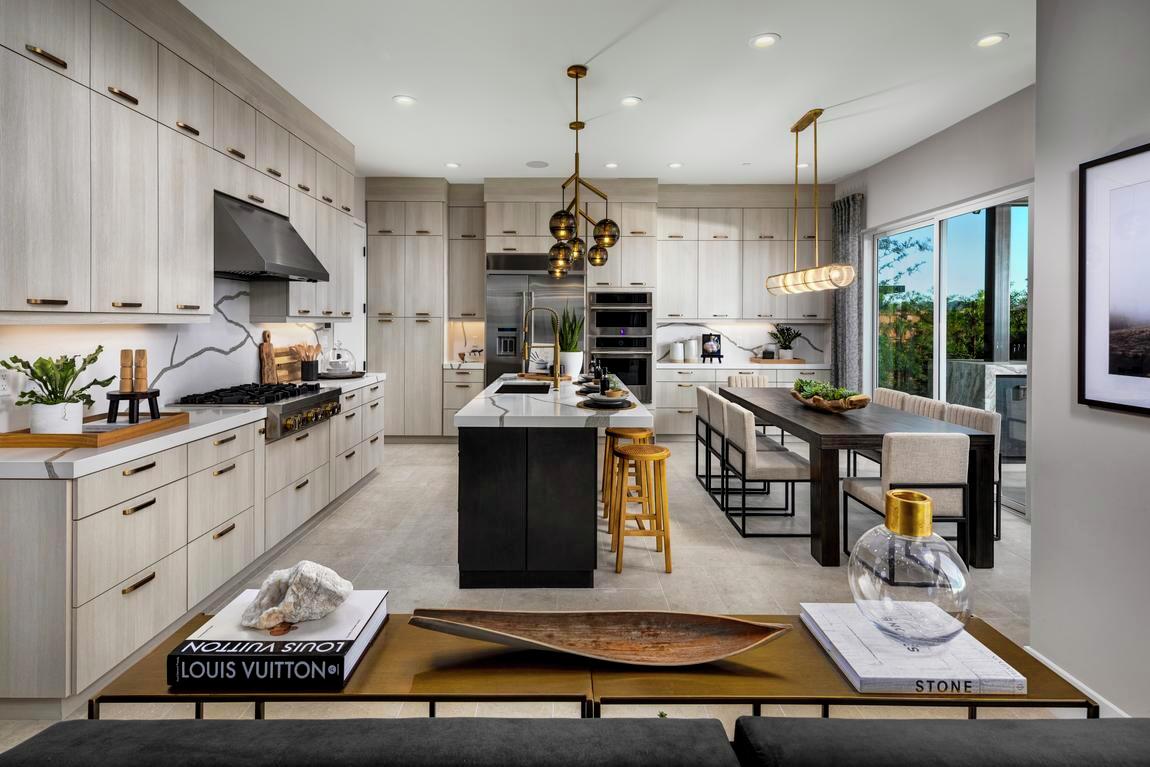 Contemporary kitchen featuring metallic, industrial accent lighting, gray cabinetry, and marble countertops